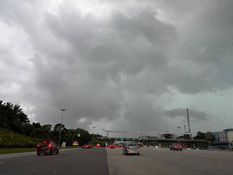 The highway view from my car on Day 1 — driving toward the toll plaza under a heavy, stormy sky.